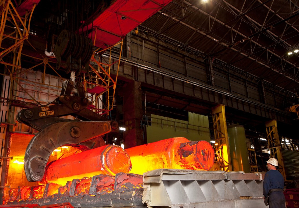 An engineer watches hot molten forged steel rods in a furnace. Photo: Juice Verve / Shutterstock