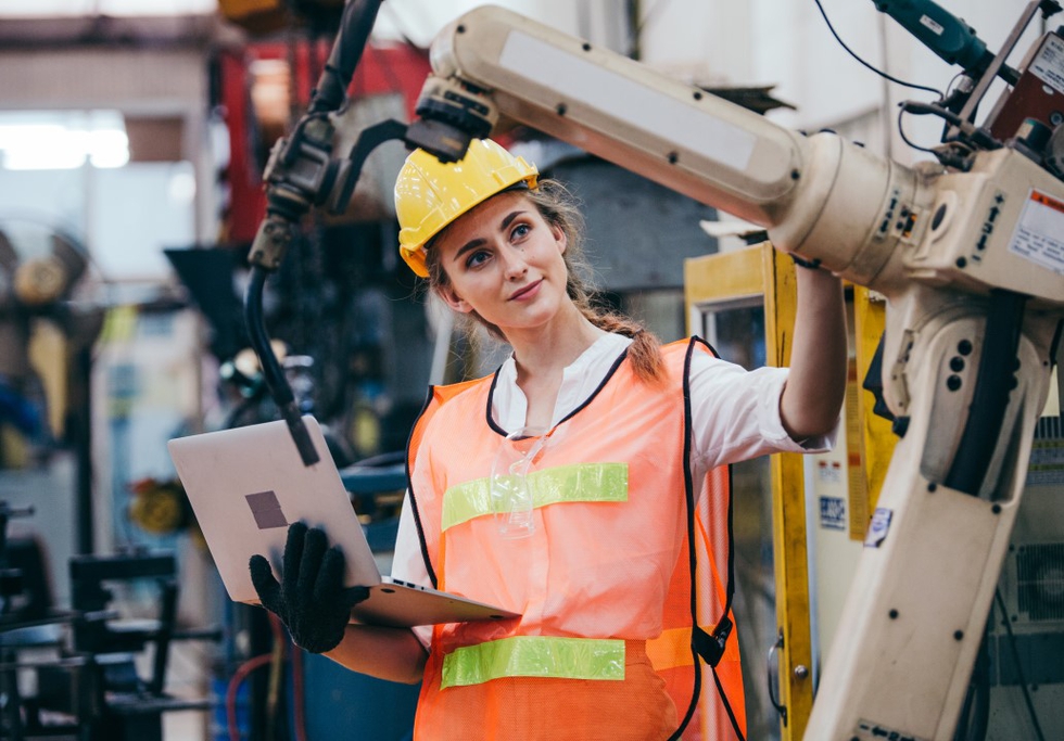 Female engineer and industrial robot. Credit: winnievinzence / Shutterstock
