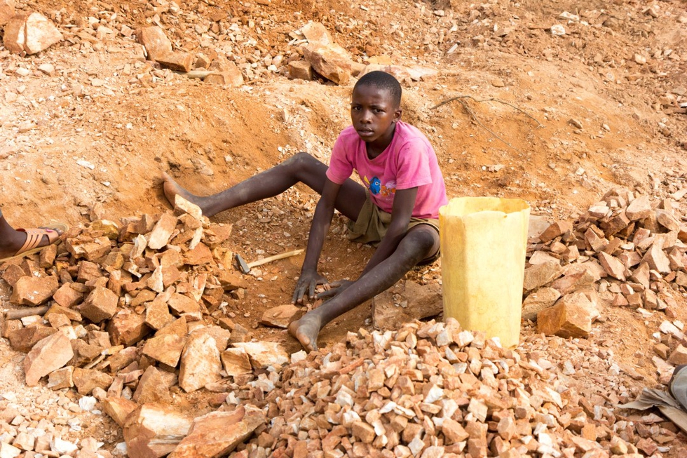 A Ugandan boy breaking rocks into small slabs. Credit: Adam Jan Figel / Shutterstock